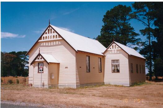 White painted weatherboard church, gabled roof, Small entrance-like extension at front, larger vestry (?) extension on side.