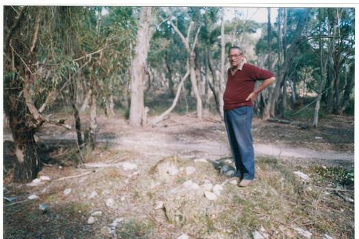 Mr Ray Willis standing beside Chinese grave site at Misery Creek, Enfield