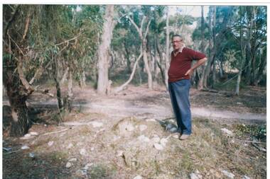 Mr Ray Willis standing beside Chinese grave site at Misery Creek, Enfield