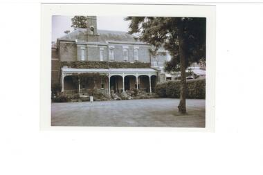 Black and white view of croquet lawn and part of Mt Boninyong homestead veranda and upper storey in the background.