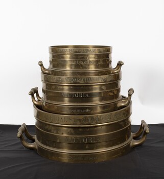 Stack of brass Imperial standard measures- Bushel, half-bushel, peck

