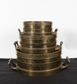 Stack of brass Imperial standard measures- Bushel, half-bushel, peck

