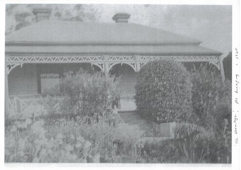 View of the front of the house showing the established garden and the lacework on the verandah