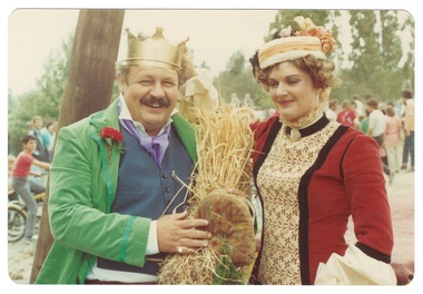 Man and woman in Victorian costume, man wearing crown, woman in pill-box hat.