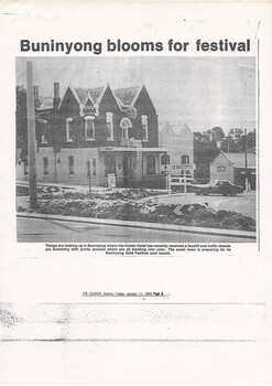 newspaper report, photo of corner hotel, two-story brick, traffic island in foreground filled with planted flowers.