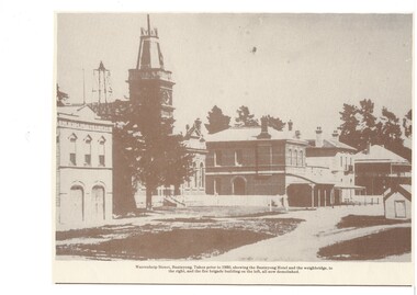 Street view, old buildings town hall with tower, several two-story commercial buildings and fire station.