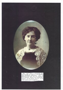 Oval head and shoulders portrait of young lady in dark dress with lace shawl, hair up.