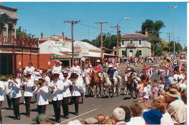 Buninyong Festival parade passing down Warrenheip Street, showing local shops on corner.