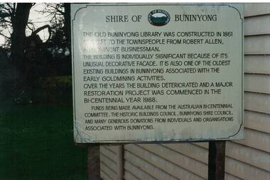 Large metal sign mounted outside side of weatherboard building