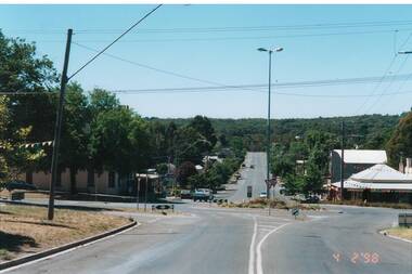 Looking across roundabout intersection, start of buildings to the right, very few cars