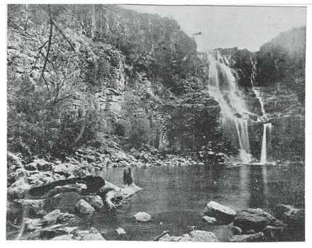 Waterfall, three drops over cliff to pool, fallen rocks around base of cliff, some scrubby plant-growth