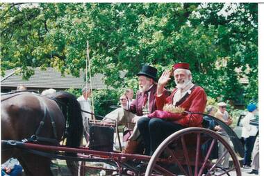 Colour photograph of Derek Leather dressed as Simon De Soza, riding as a passenger in a small horse drawn vehicle in the Gold King Festival Parade