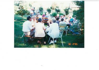 Colour photograph of Buninyong Primary School class of 1940 members seated at tables in the garden of the Buninyong Old Library 18 February 1995