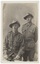 A black and white image of two unknown World War 1 Australian Soldiers in uniform, one seated, one standing