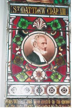 Close view of the lower panel of the stained glass window featuring an image of Rev. Thomas Hastie showing part of the memorial inscription