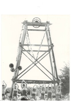 Black and white photograph of replica Poppet Head in De Soza park and participants in the Gold King Festival 1983