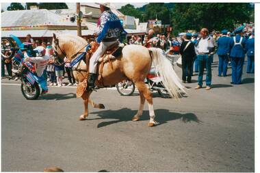 Colour photograph of the Buninyong Festival Procession 1993 featuring Rocky Western from Maryborough, Best Ridden Entry riding next to some motorbike riders