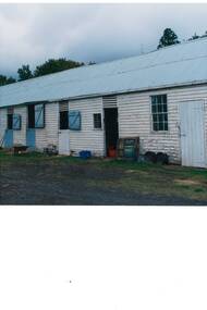 Colour photograph of part of a long weatherboard stable block at Mt Boninyong estate showing 4 stable doors, additional doors and windows and evidence of various alterations 