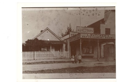 Butcher's refreshment rooms and residence circa 1890s in Learmonth Street Buninyong, three small children standing in foreground, part of old fire station visible on right
