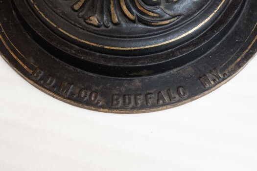 A raised inscription on the circular base of the nitrous oxide gasometer that reads "B.D.M. CO, BUFFALO N.Y."