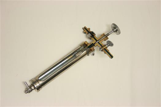 Sectioned metal cylinder with glass inner chamber and gauge inside.