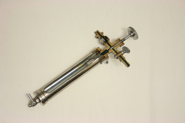 Sectioned metal cylinder with glass inner chamber and gauge inside.