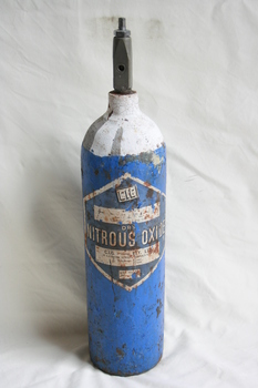 Blue coloured cylinder with rounded base and painted white neck. A large blue on white diamond shaped label is adhered onto the body.