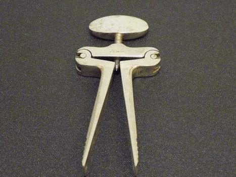 Scissor-like metal device with a screw mechanism at the top which allows for the open or closed position to be locked.