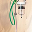 Attached to an upright pole, the four metal casters make this apparatus portable. The green tubing is indicative of a Bird Ventillator. 