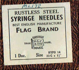 A small box with a mottled brown lid, underneath a greenish manufacturer's label with black printed text.
