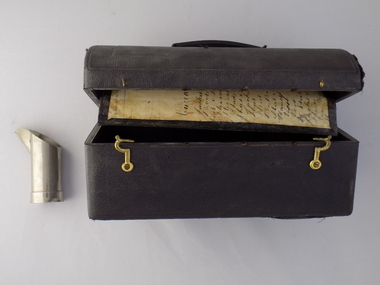 A black doctor's bag with brass clips, where manuscripts have been used as the lining for the bag.