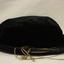A navy blue velvet cloth bonnet with stiffened brim covered in same fabric as bonnet with a gold cord and tassles tied around it.