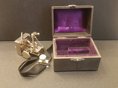 Housed in a purple-lined, leather case with a metal hinge and clasp, the sphygmograph had a black fabric strap which is used to attach to the patient’s wrist.