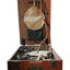 The reddish wood box is scratched and dented, and contains a system of rubber tubing and metal elements which act as an artificial respiration machine.