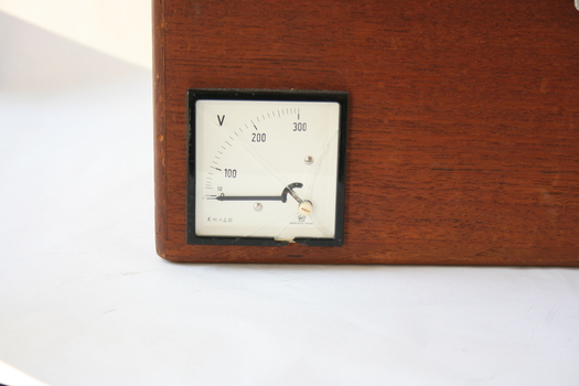 The white, square gauge on the face of the wooden box has measured numbers up to 300, although there is no indication exactly what is being measured by the gauge.