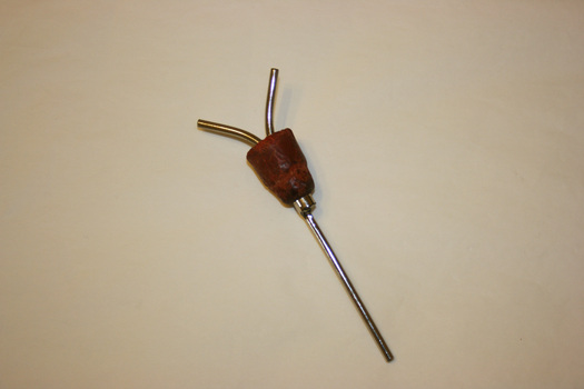 "Y" shaped hollow metal rod with a red rubber stopper at the intersection of the "Y".