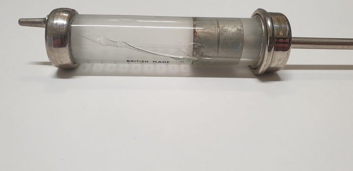 Glass barrelled syringe, revealing cracked glass along entire length of barrel.
