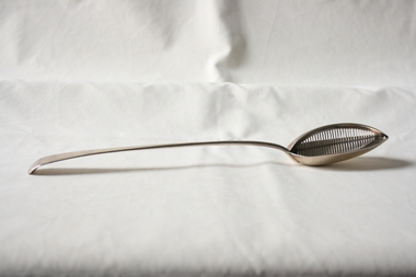 A sterling silver gravy spoon.