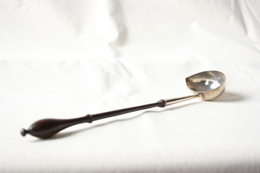 A sterling silver and wood punch spoon.