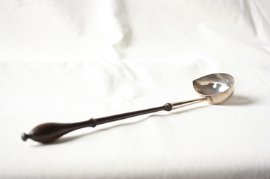 A sterling silver and wood punch spoon.