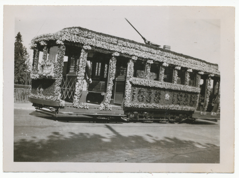 Vintage tramcar decorated with thousands of flowers for a celebration, with "VIEW POINT" visible on the front.