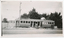A vintage tramcar with number 22 visible on its side, stopped on grassy land next to a road, with a wooden fence and trees in the background.