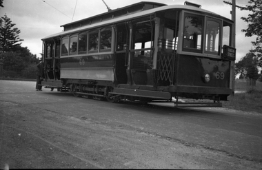 Tramcar numbered 69 with an "RUBICON STREET" sign, parked on a street with a man standing at the rear.