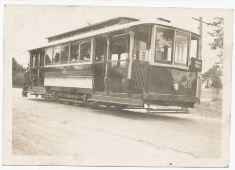 Tramcar numbered 69 with an "RUBICON STREET" sign, parked on a street with a man standing at the rear.