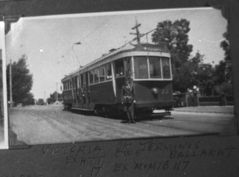 Tramcar with destination of "Mt Pleasant" and numbered 22, with a conductoress standing beside it on a street in front of trees and a stone wall.