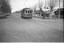 Vintage tram numbered 27 traveling down a tree-lined street in a residential area.  A lady is walking across to the footpath after alighting from the tram.