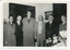 Six men in suits and overcoats pose for a formal photograph.