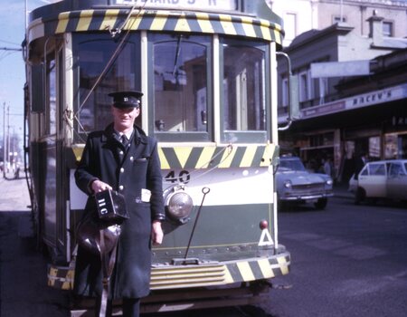 conductor 11 (R. Walker??) holding bag and cash tin,