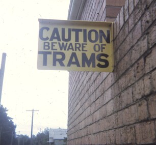 "Caution Beware of Trams" sign on the depot wall.