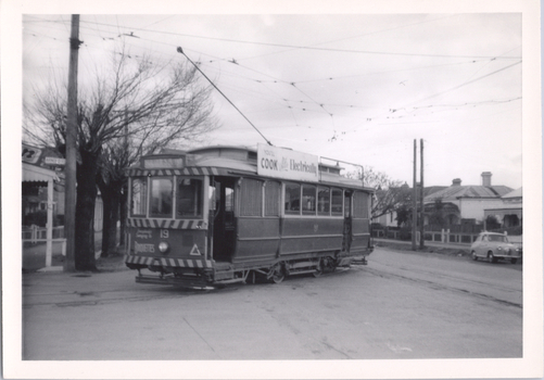 Tram 19 running out the depot lead into McCrae St with an SEC Cooking roof and a Briquettes dash canopy advertisements.